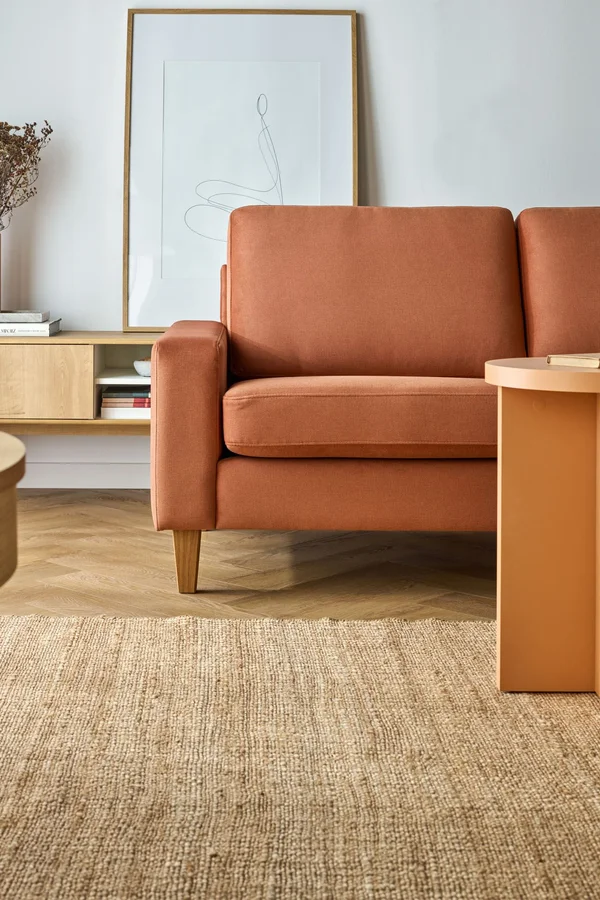 ruda sofa i pomarańczowy stolik kawowy